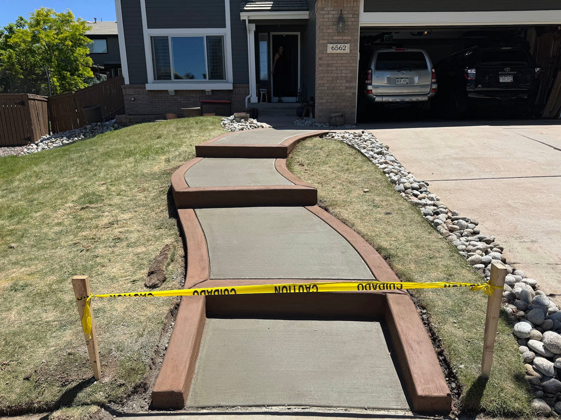Custom curved concrete walkway in Highlands Ranch featuring integrated steps and a 6-inch Buff Tan decorative border.