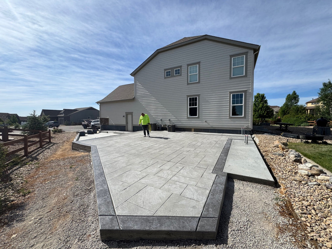 Large Stone Gray stamped concrete patio featuring a Dark Gray textured border, monolithic shed foundation, and future outdoor kitchen area by Pristine Concrete Denver.