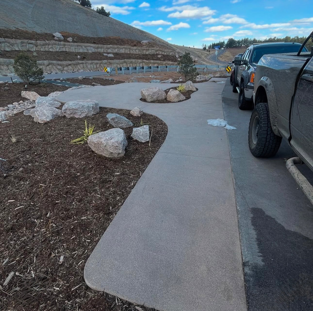 Finished community mailbox concrete pad with rock and mulch landscaping in Boulder, Colorado