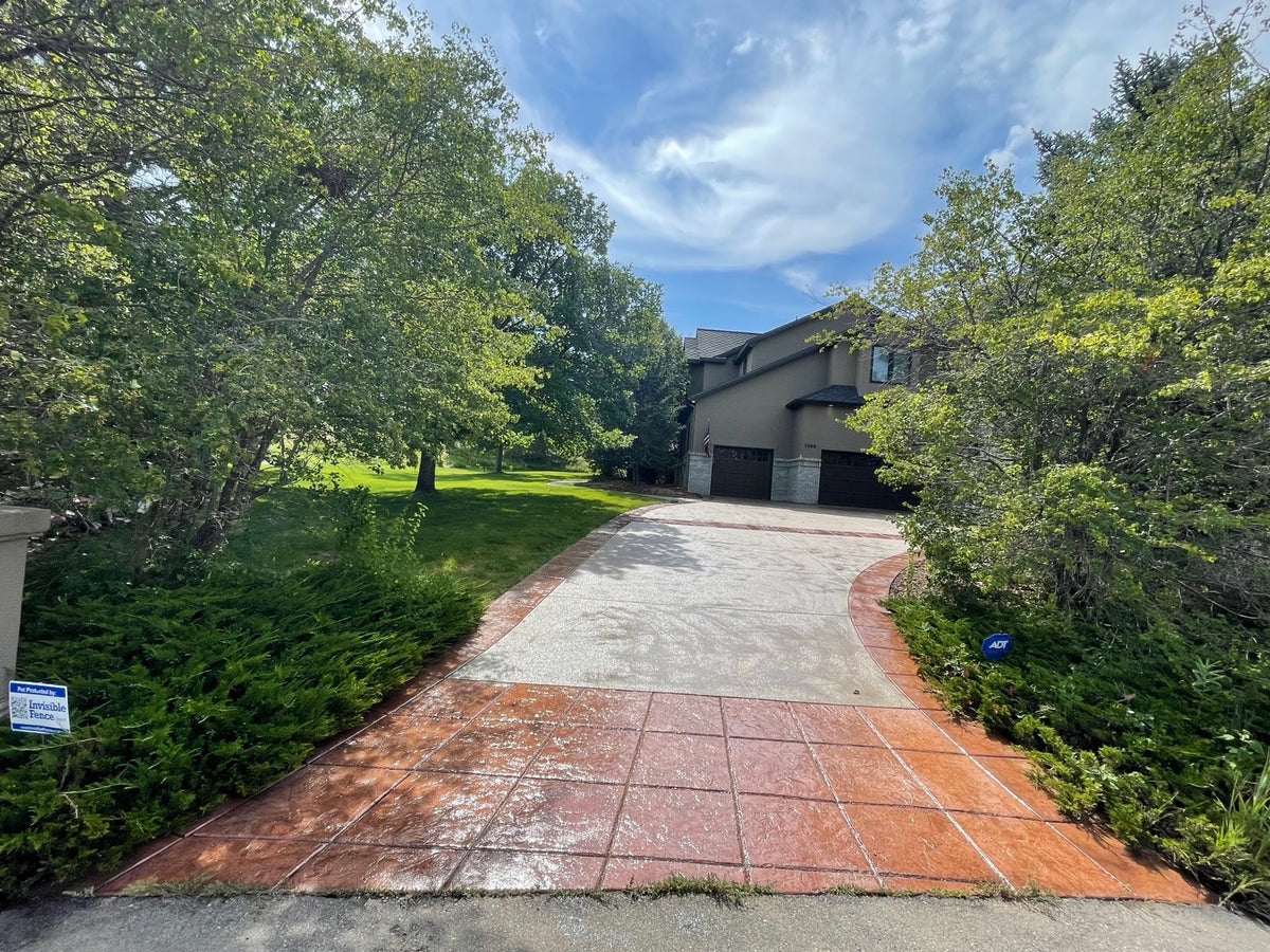 Decorative concrete driveway with a red stamped concrete border in the Denver area