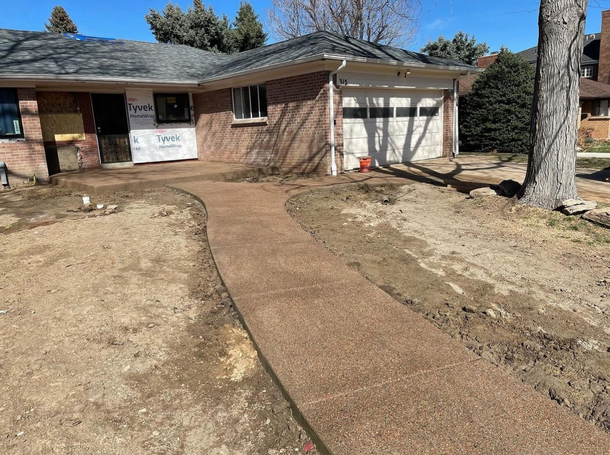 Curved sand finish concrete walkway leading to a home’s front porch in the Denver area