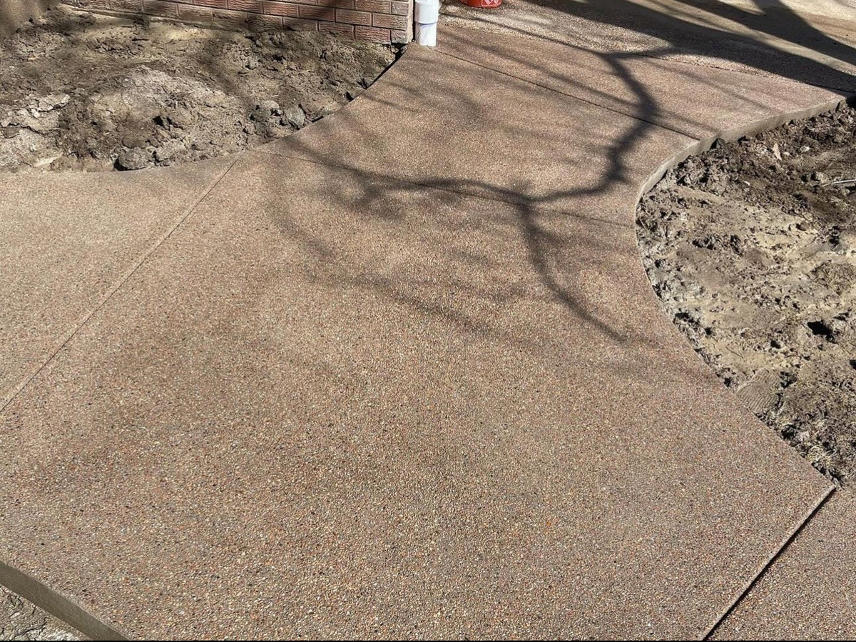 Close-up of the fine, evenly exposed texture of a sand finish concrete walkway